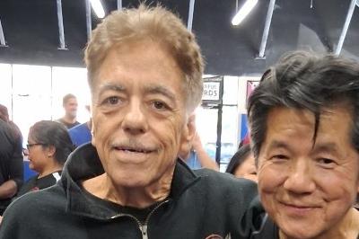 Sifu McElroy and Sifu Francis Fong standing side-by-side, smiling arms around shoulders