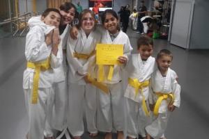 MMAA boys and girls standing together showing off their new yellow belts