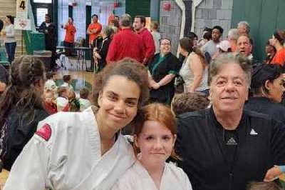 Sifu McElroy standing surrounded by his young students with other teams in background