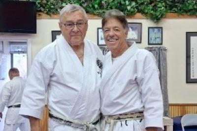 Price and McElroy posed standing smiling wearing Karate gi 