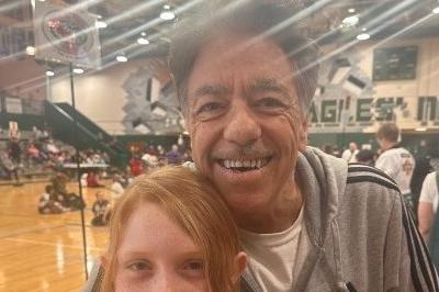 Abigail standing smiling proudly showing blue first place ribbon with Sifu McElroy standing behind her smiling with arm around her shoulders.