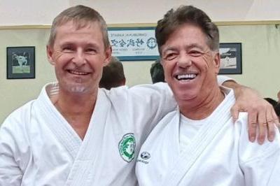 Standing posed Backteman and McElroy with other black belt participants reflected in mirror behind them
