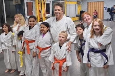 Nine MMAA Boys and Girls with McElroy posed standing smiling wearing new belts - viewed from right