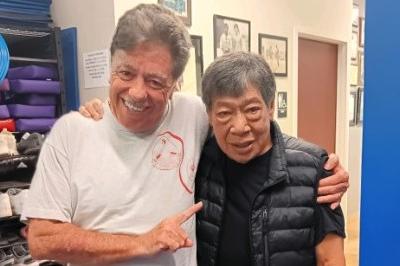 McElroy and Chai posed standing arms on shoulders smiling